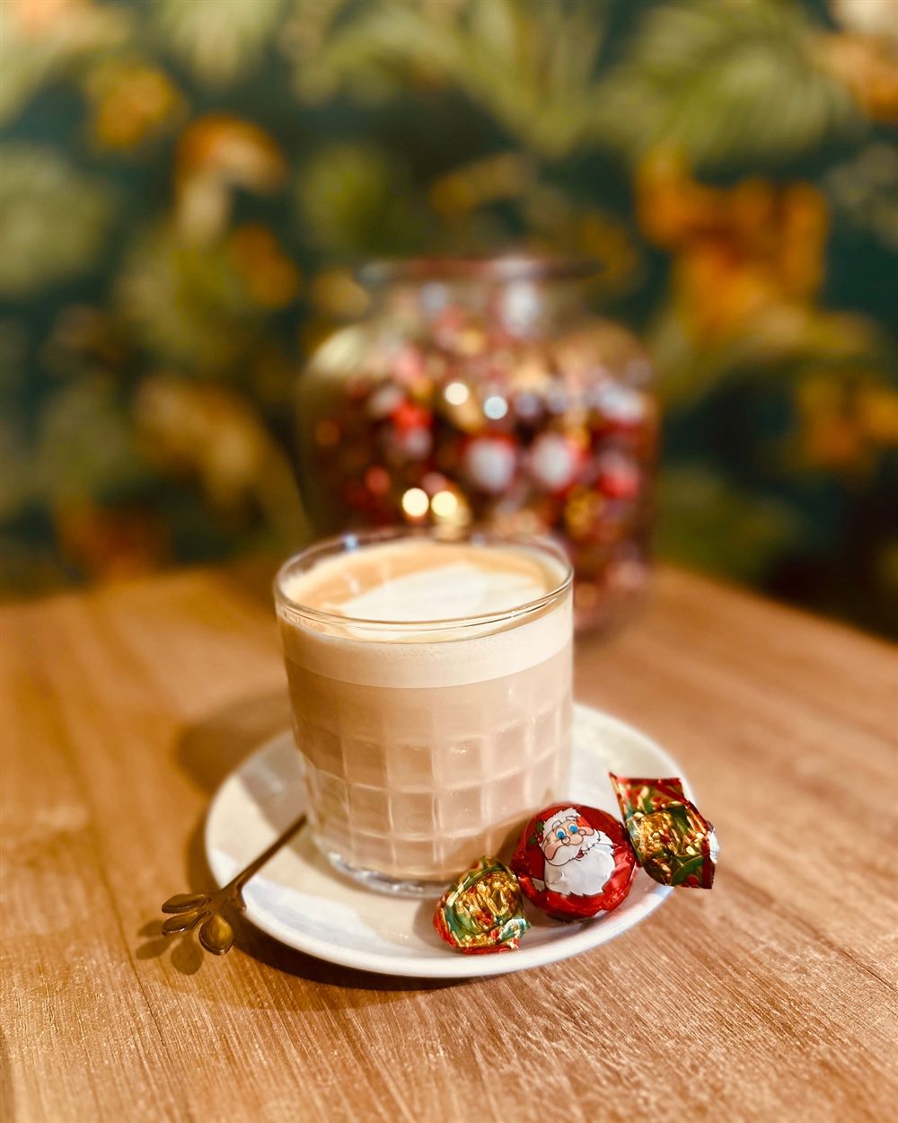 Café con leche en vaso de cristal con bombones