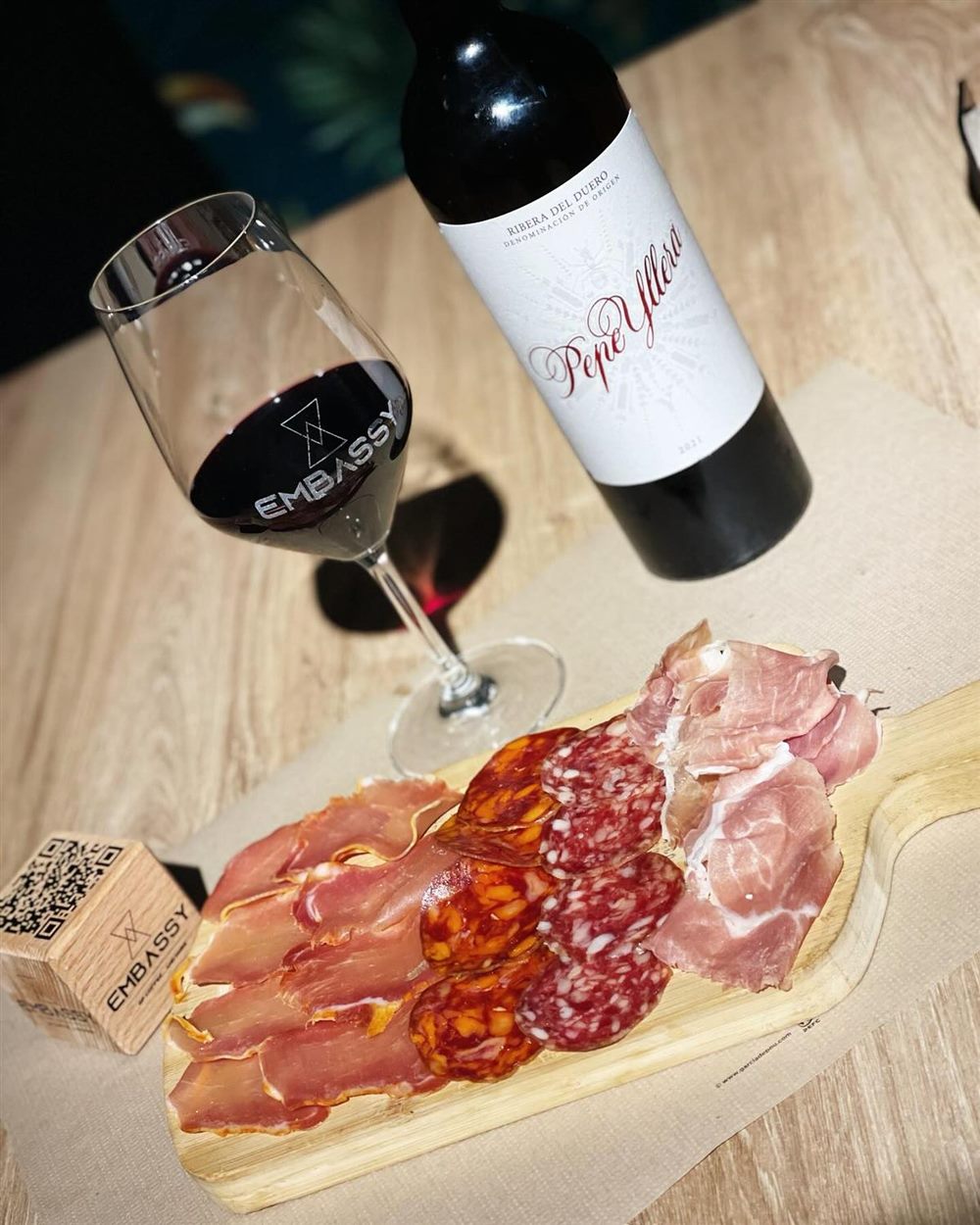Copa de vino tinto con tabla de embutidos